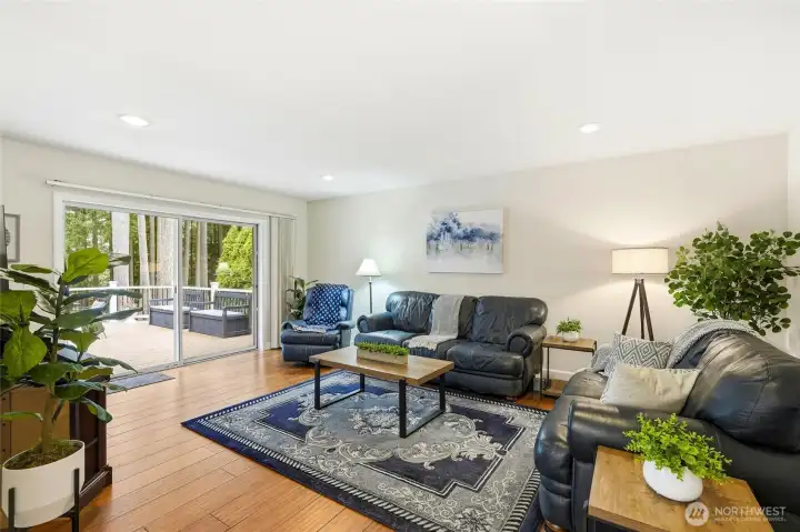 Spacious living room with fireplace, bamboo flooring, and large windows bringing in natural light and scenic Lake Wilderness views.