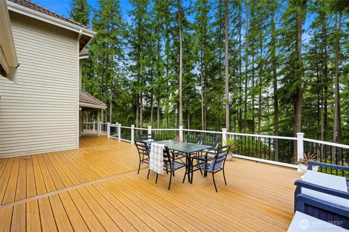 Private deck seating area overlooking mature trees and Lake Wilderness—ideal for outdoor dining and entertaining.
