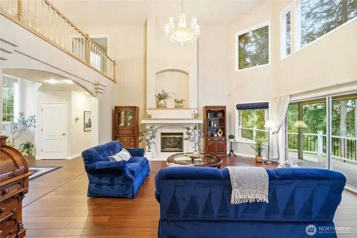 Open great room design with soaring ceilings, abundant windows, and panoramic Lake Wilderness views creating a bright and inviting atmosphere.