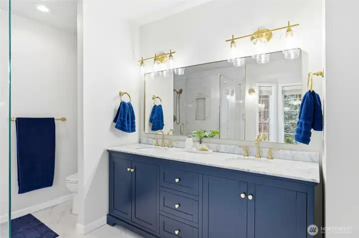 Elegant dual vanity with updated cabinetry, modern lighting, and generous counter space in the remodeled primary bath of this Maple Valley luxury home.