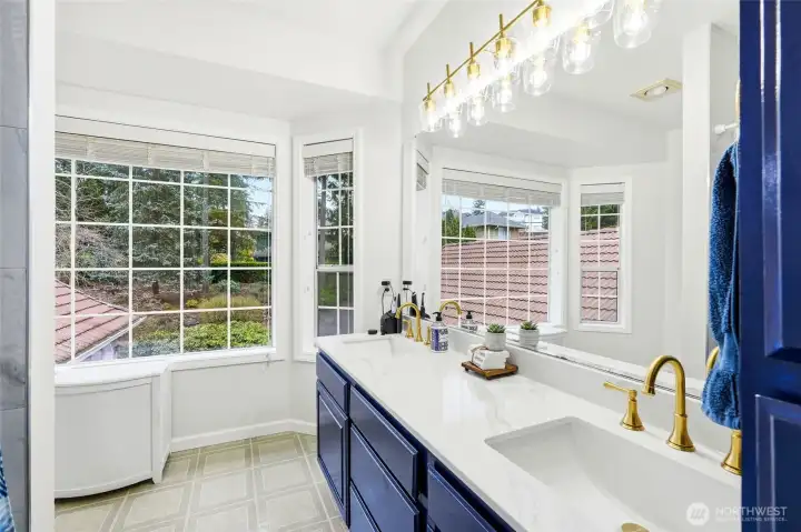 Bright and open primary bath with soaking tub, dual sinks, and walk-in shower, offering updated finishes and tranquil Northwest ambiance.