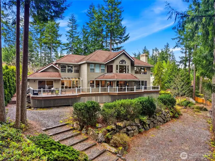 Full rear exterior view highlighting the expansive 1,400 sq ft Trex deck, multiple slider access points, and seamless indoor-outdoor entertaining design.