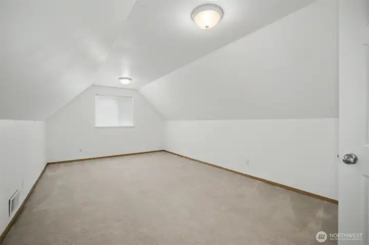 Versatile upstairs bonus room with vaulted ceiling...ideal for a bedroom, workout space, or home office.
