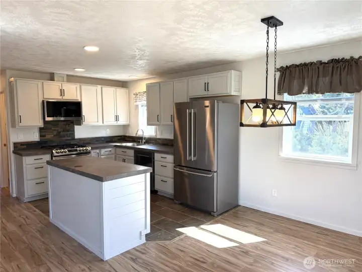 An island provides additional prep space with a little surprise in the center, a pop-up electric plug-in when needed and push back down when not needed.