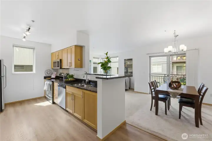 Dining area with a clear view into the kitchen and abundant natural light