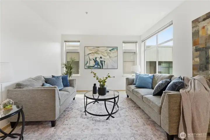 Inviting living room with generous windows and a calm, airy feel.