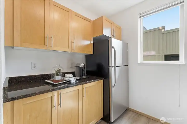 Kitchen corner featuring stainless steel appliances and warm maple cabinetry