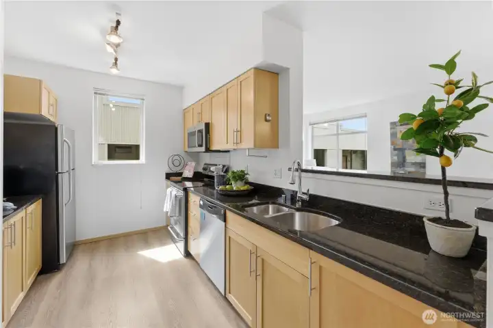 Additional kitchen view highlighting granite countertops and maple cabinetry