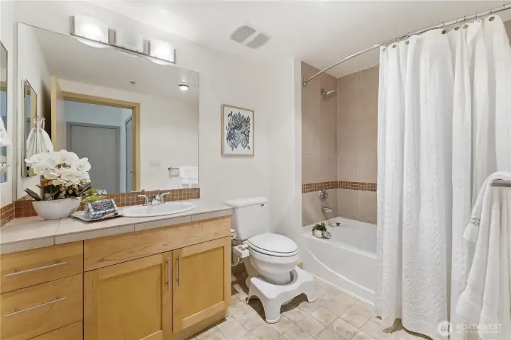 Well-appointed primary bathroom with a spacious vanity and tub/shower combination