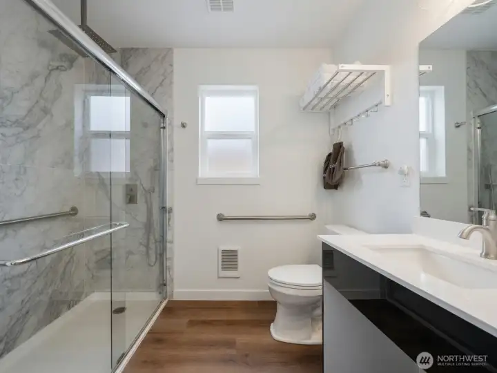 Accessible 3/4 bathroom with grab bars and roll-in shower
