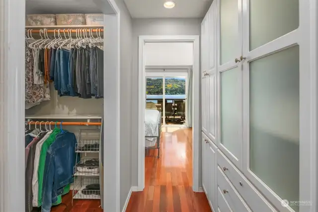 A hallway from the primary suite leads to a walk-in closet, and a large wall of built-in closets.