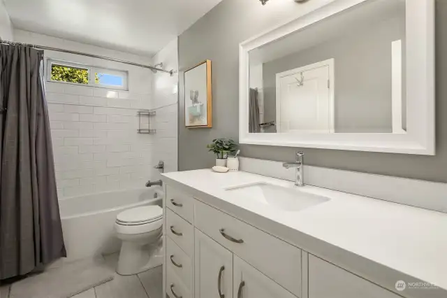 Adjacent to the upper-level third bedroom is the remodeled en-suite bathroom with the similar stylish finishes carried through--quartz counter vanity, tile floors, and subway tiled bathtub/shower.