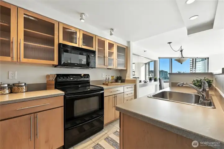 Lovely, updated open style kitchen with warm Maple cabinetry & Corian countertops!