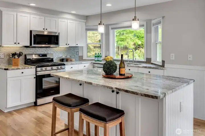 Large island with slab granite countertops.