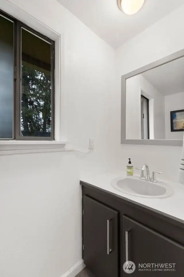 Half bath with barn door located off the kitchen and utility room.