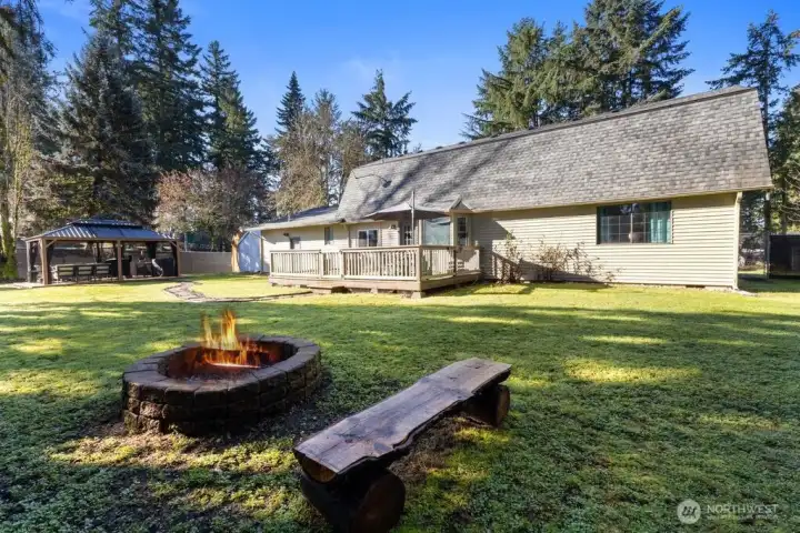 View of the backyard and firepit area with benches.