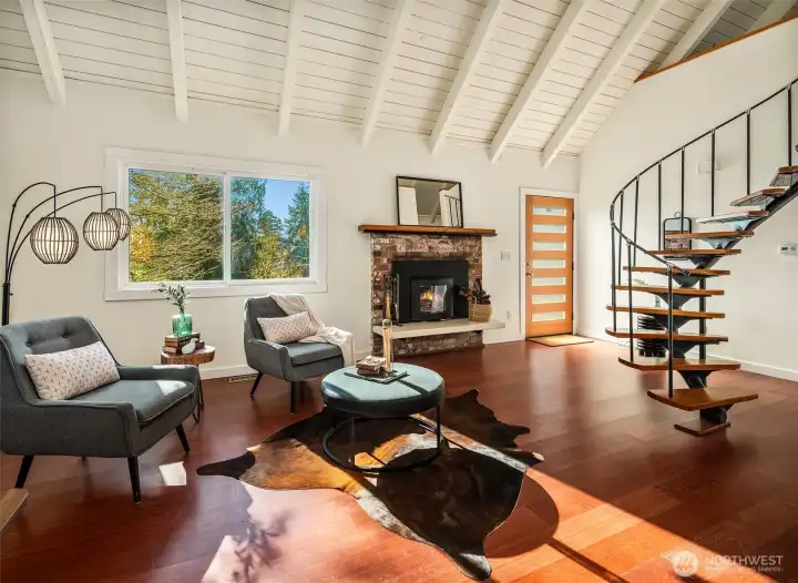 South-facing window, entry door and fun stair to loft. Loft stair was built by Vashon High School students under the tutelage of master craftsmen. Wood insert is state-of-the art and easily warms the spaces.