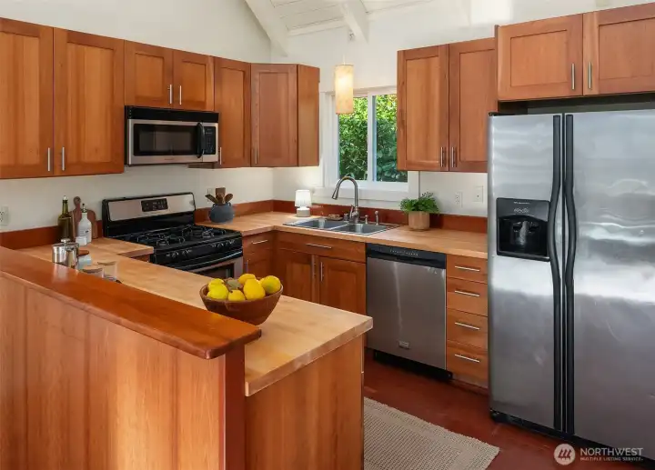 Generous but compact kitchen with custom cabinets and butcher block countertops.
