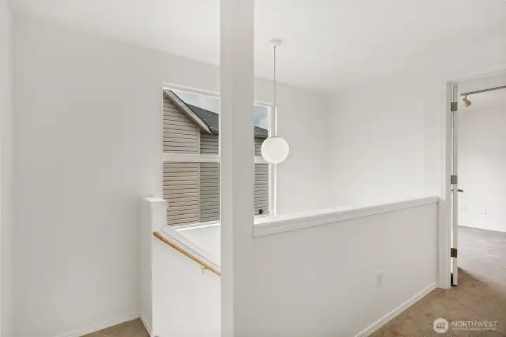 Large windows in stairwell going up to 3rd floor - and another bookcase nook in landing.