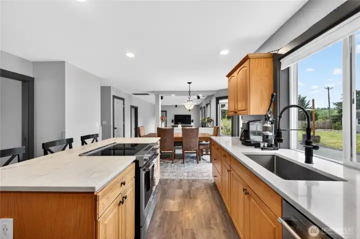 Beautifully updated kitchen showcases brand-new quartz countertops, stainless steel sink, newer downdraft oven and dishwasher, ample cabinet and counter space, and an easy-flow layout ideal for gathering and meal preparation.