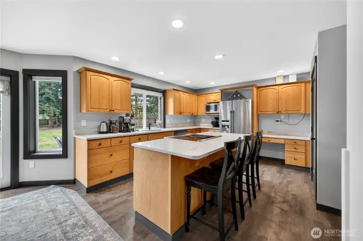 Additional view of the kitchen showing the center island with bar and extra dining space.