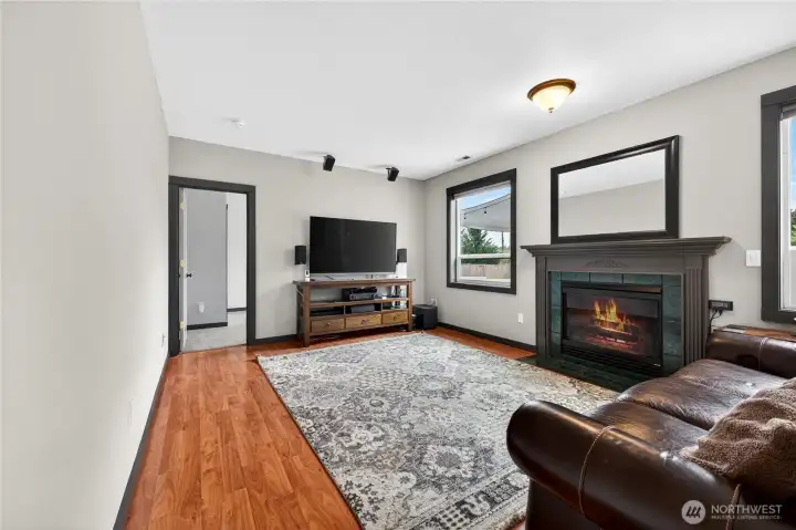 Spacious living room designed for both everyday living and entertaining, featuring updated flooring, wired surround sound, abundant natural light, fireplace, and an inviting open feel that flows seamlessly into the kitchen and dining areas.