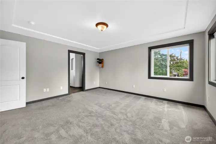 Spacious primary suite provides a relaxing retreat with abundant natural light, newer flooring, walk-in closet, and private ensuite bathroom designed for comfort and functionality.
