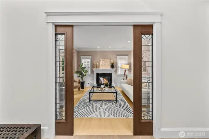 Gorgeous glass doors open to a front living area with a cozy fireplace. This room could also flex as an office, or formal dining area.