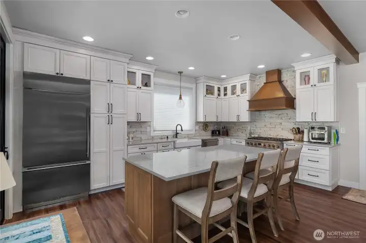 Kitchen with gas stovetop, plenty of storage, cabinetry is custom, and eat-in kitchen bartop