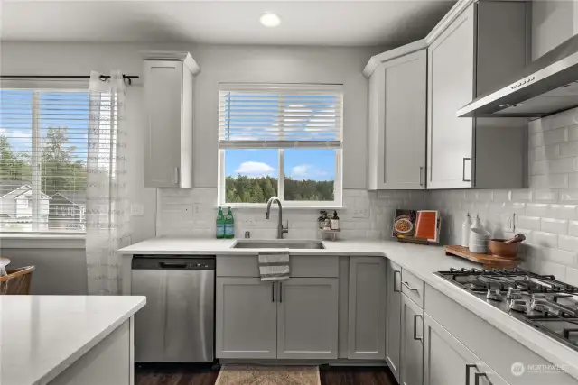 Simply beautiful!  White quartz counters blend harmoniously with shaker style cabinetry and subway tile for a simple yet elegant look.