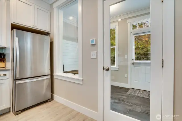 Off of the kitchen is a mudroom/office/playroom. The large window and transomed windows above the doors allow more light to shine through.