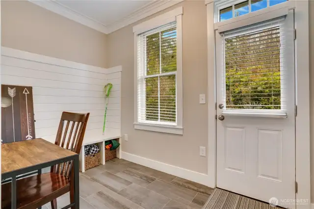 Shiplap details, a built-in bench, and crown molding in here add to the elevated look of this home! Don't miss the easy to maintain tile floors too. The door heads out to the back patio where there is a barbeque, hot tub, and seating.