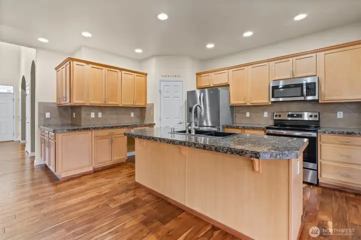 Warm cabinetry, stainless appliances, and Acacia hardwoods that tie it all together
