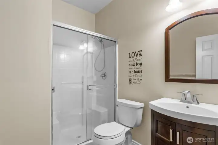 Main-level bath with glass shower and modern finishes — perfect for guests or everyday convenience
