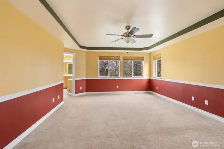 spacious primary retreat with Coffered ceilings and peaceful greenbelt views