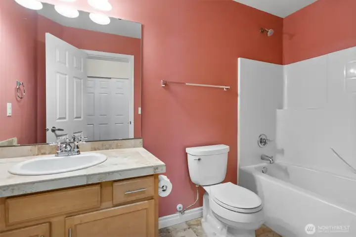 Well-appointed full bathroom with tub/shower and generous vanity storage