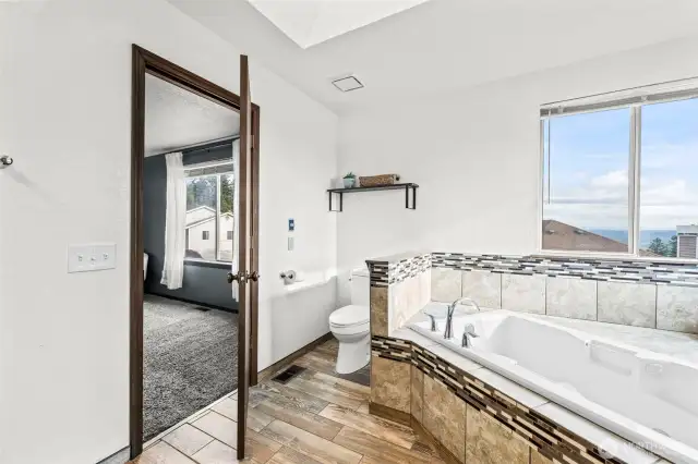Tile flooring, an oversized soaking tub, & stunning views