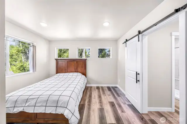 Second floor primary bedroom with plenty light, barn door accents to primary bath
