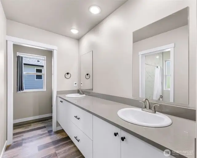 Primary bath has dual floating vanity with soft close cabinets and quartz counter tops and access to walk in closet