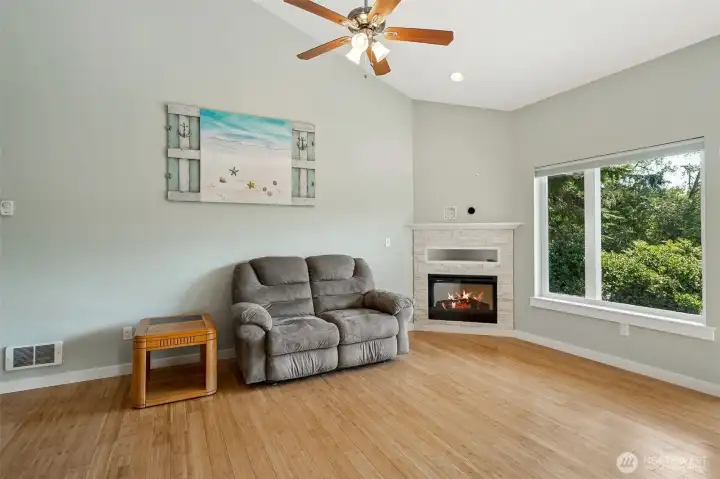Living room comes complete with a fireplace, ceiling fan and easy views of the water.