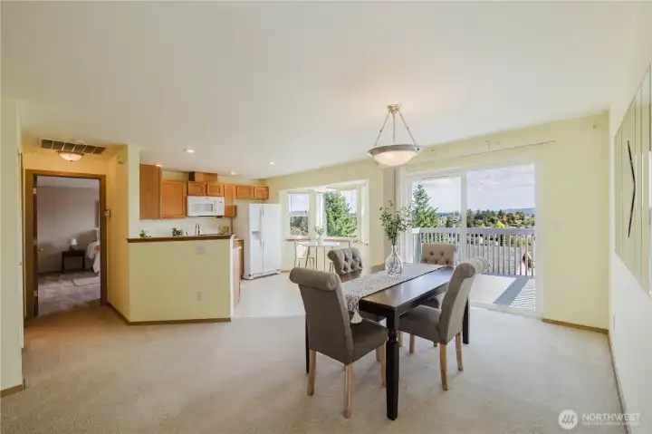 The dining room with partial view of the kitchen and deck. Stunning views from all windows!