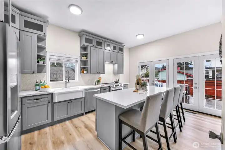 Beautiful designer kitchen with quartz counters, farm sink and stainless appliances.