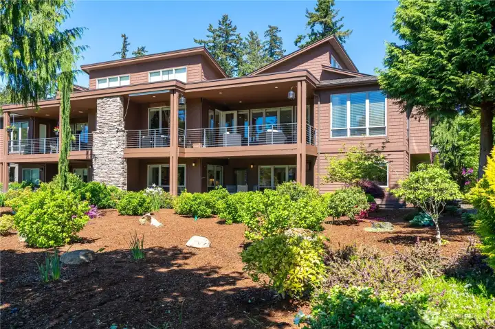 Rear exterior featuring covered decks and landscaped grounds Rear exterior featuring covered decks and landscaped grounds