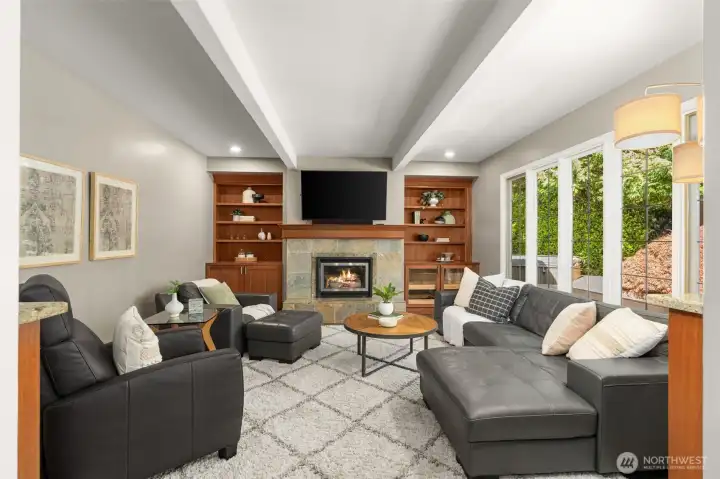 Family room is adjacent to kitchen, with updated built-ins and gas fireplace
