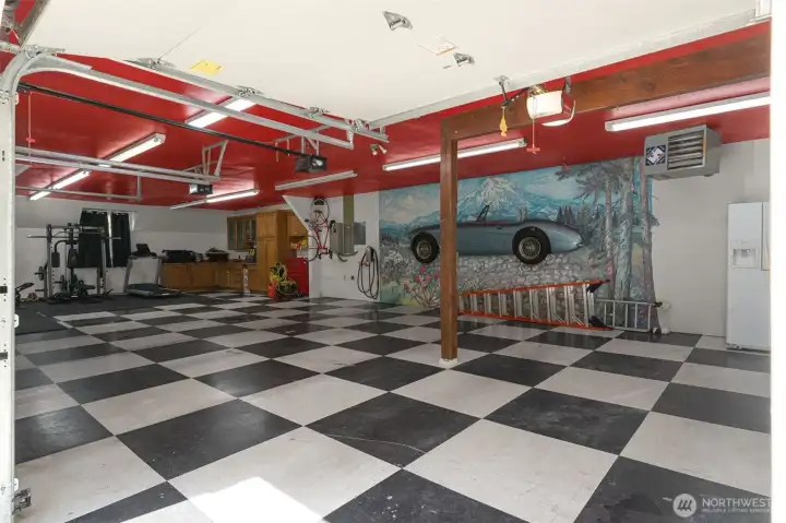 This 5 car heated garage is really special. The mural is made from an actual car! Currently used as 3-car garage plus home gym and workshop. 2 additional cars can fit in gym/workshop space.