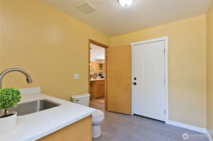Garage mud room with toilet and sink