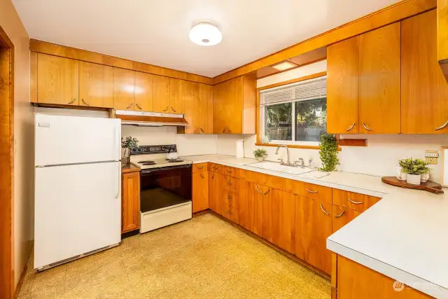 Original cabinetry and hardware with plenty of storage space and counter for prep work.