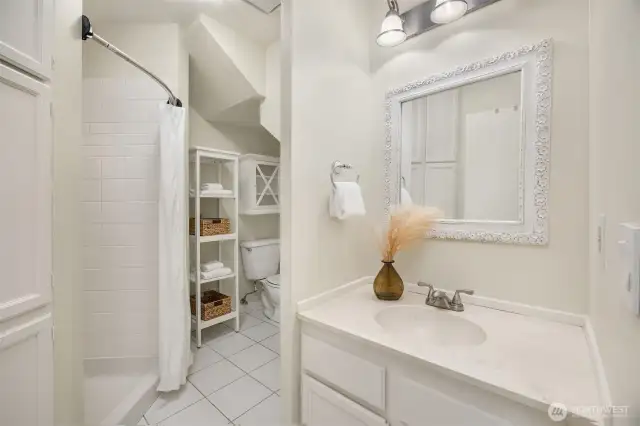 Bright bathroom just off the lower-level rec/bonus room with a shower and tile floors.