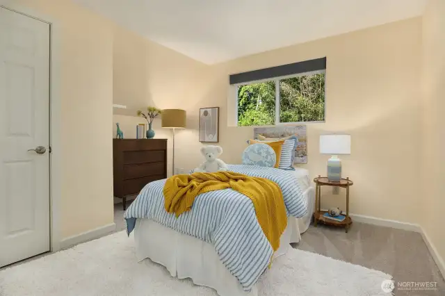 Charming Bedroom #2 on the same level as the primary suite, offering peaceful views of the trees and newly installed carpet.