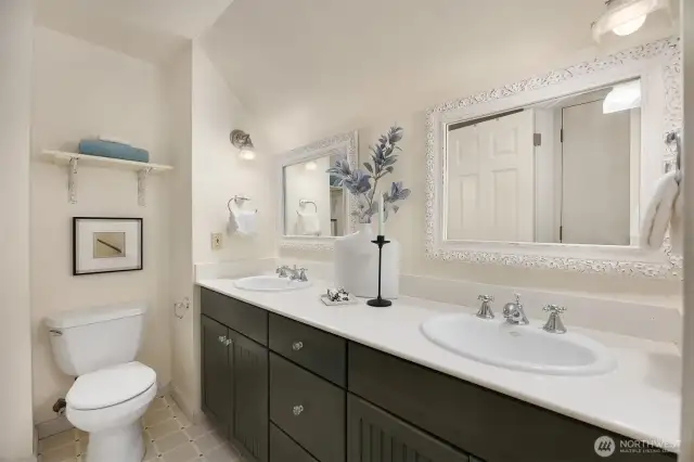 Full bathroom conveniently located near both bedrooms, featuring dual sinks and generous storage.